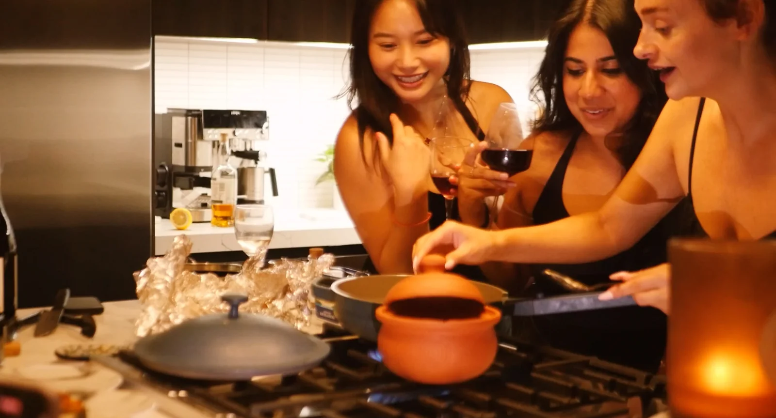 Friends lifting the lid off the Mitipot at dinner